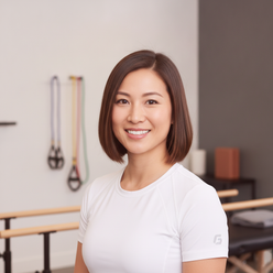 Portrait of Dr. Emily Chen, a physical therapist, smiling confidently in a professional setting.